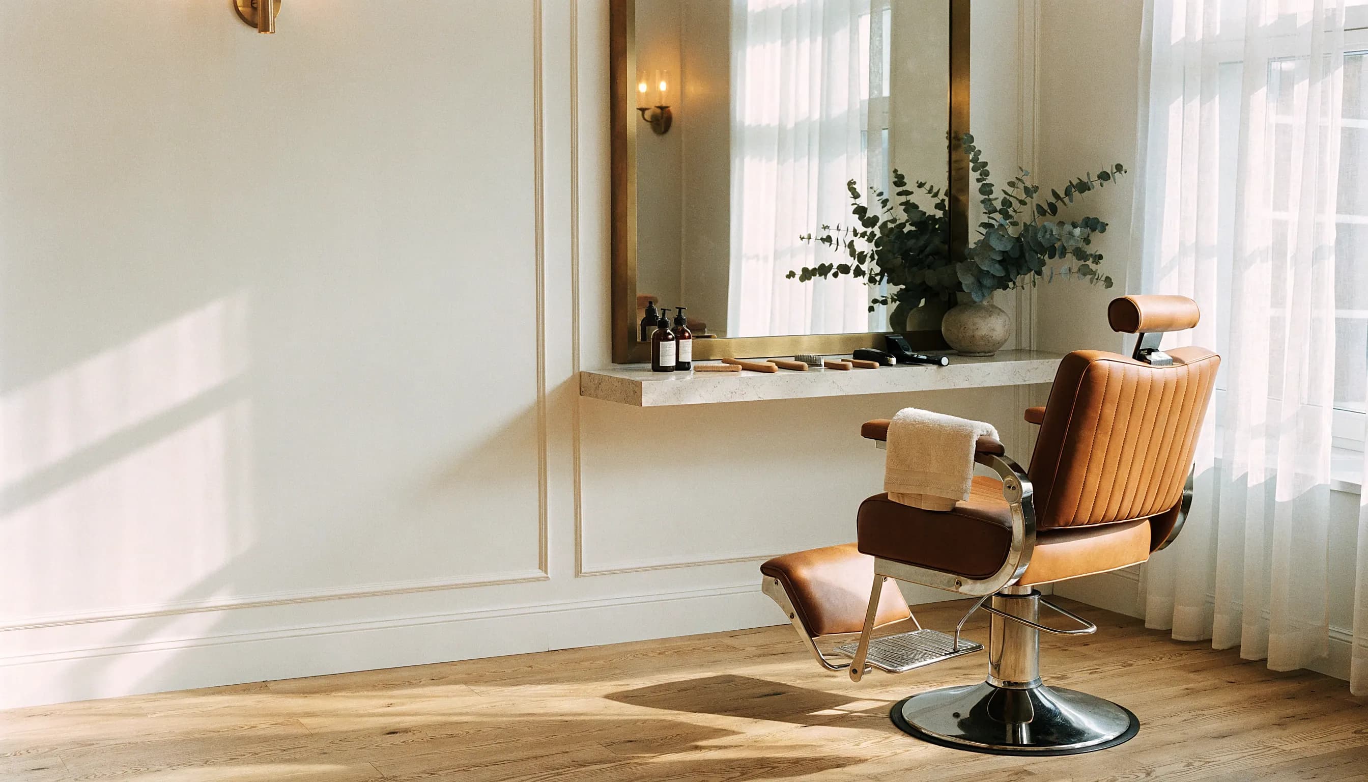 An upscale grooming lounge in the late afternoon, a cape folded over the chair arm
